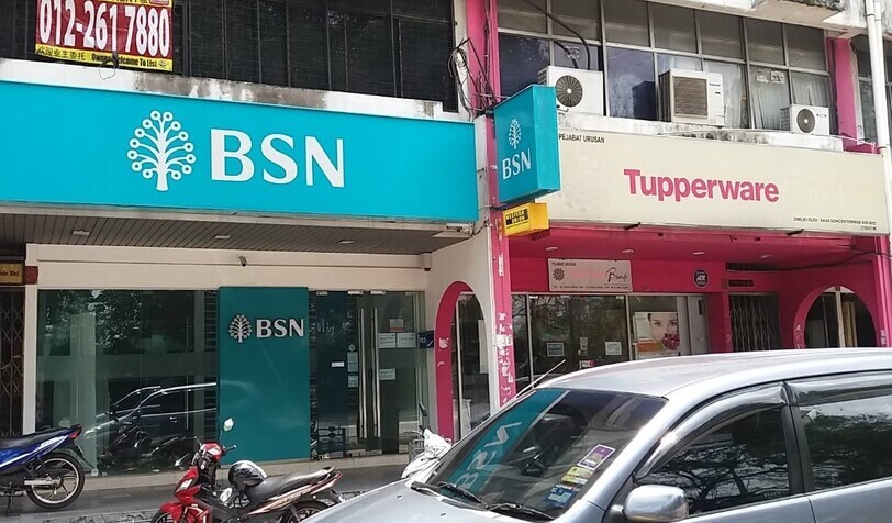 Pandangan hadapan cawangan Bank Simpanan Nasional (BSN) berpusat di premis rumah kedai, terletak bersebelahan kedai Tupperware dengan motorsikal dan kereta diletakkan di hadapannya