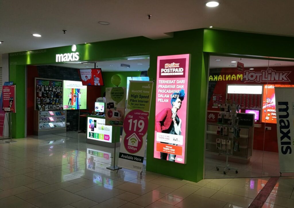Foto kedai Maxis dan Hotlink hijau dan merah terang di pusat beli-belah AEON Big Wangsa Maju
