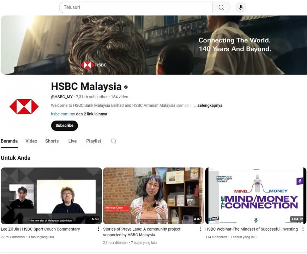 Tangkapan skrin saluran YouTube HSBC Malaysia. Bahagian atas halaman memaparkan sepanduk dengan patung singa emas yang besar dan teks "Connecting The World. 140 Years And Beyond." Di bawah sepanduk terdapat nama saluran "HSBC Malaysia" dan pemegangnya "@HSBC_MY." Ini menunjukkan bahawa saluran itu mempunyai 7.31 ribu pelanggan
