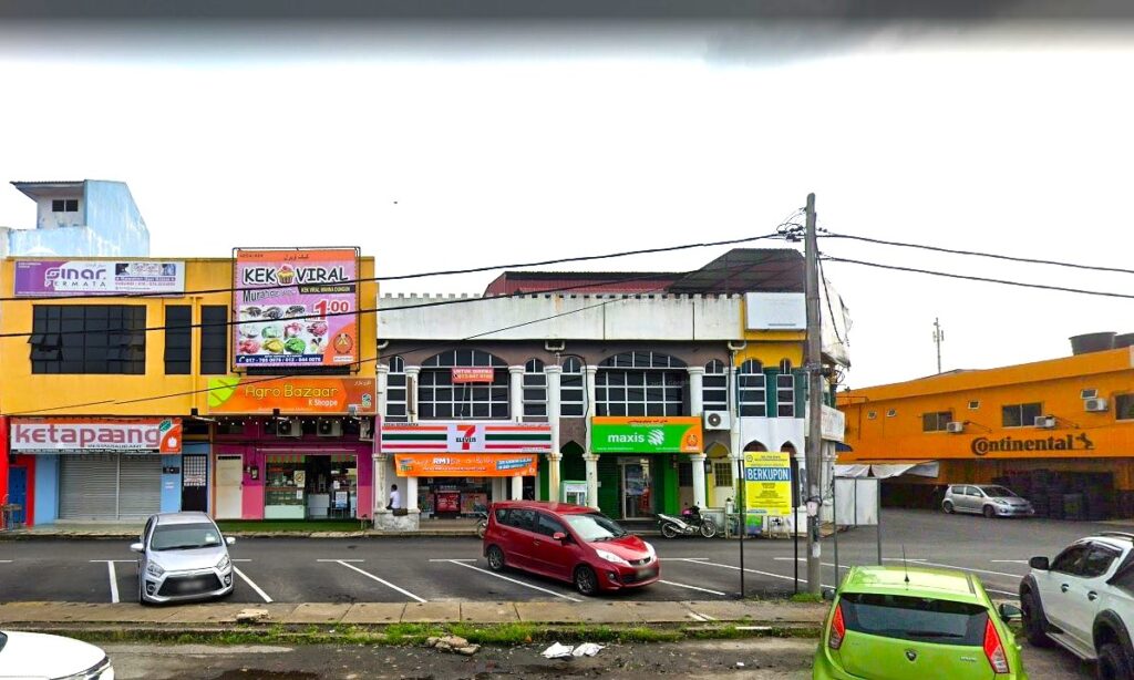 Foto deretan kedai komersial bertingkat rendah berwarna-warni di Dungun, Malaysia. Beberapa perniagaan yang dilihat termasuk 'Sinar Optik' berwarna kuning dan hitam, kedai roti 'Kek Viral' berwarna merah jambu, kedai serbaneka '7-Eleven' berwarna merah dan putih dan 'maxis' berwarna hijau