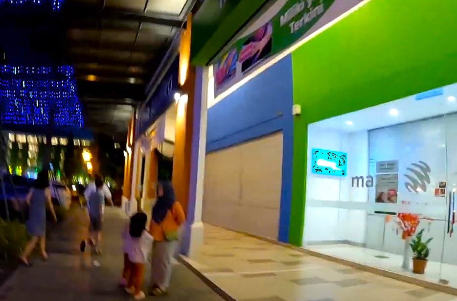 Bahagian luar kedai Maxis Centre pada waktu malam, terletak di Miri Times Square, Sarawak. Muka kedai bercahaya terang, dengan nama kedai boleh dilihat pada fasad hijau dan biru