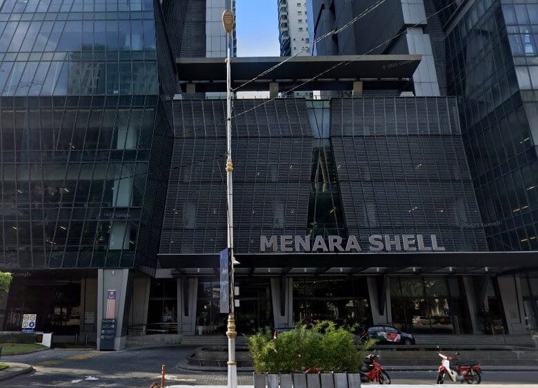 Pintu masuk dan fasad bawah bangunan moden bertingkat yang dipanggil Menara Shell. Bangunan ini mempunyai reka bentuk kontemporari yang anggun dengan penggunaan meluas kaca dan bahan berwarna gelap. Bahagian tengah fasad bawah mempunyai bahagian yang besar, gelap, berkisi atau berlorek, berbeza dengan panel kaca yang jelas dan reflektif di menara sekeliling