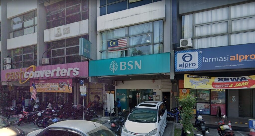 Eksterior pejabat BSN Sungai Besi. Terletak di kawasan komersial. Terdapat kiosk di sebelah kanan dan kiri. Logo BSN boleh dilihat pada kaca dan pada bahagian luar bangunan