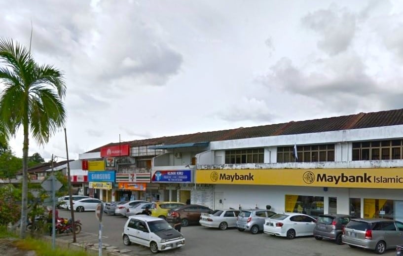 Gambar siang hari menunjukkan deretan kedai, termasuk Maybank dan Maybank Islamic, di Jalan Besar, Kampung Baru Karak. Bangunannya dua tingkat, dengan papan tanda di tingkat bawah. Beberapa buah kereta diparkir sembarangan di hadapan kedai. Kedai-kedai tersebut mempunyai papan tanda untuk Samsung, 7-Eleven, dan sebuah klinik
