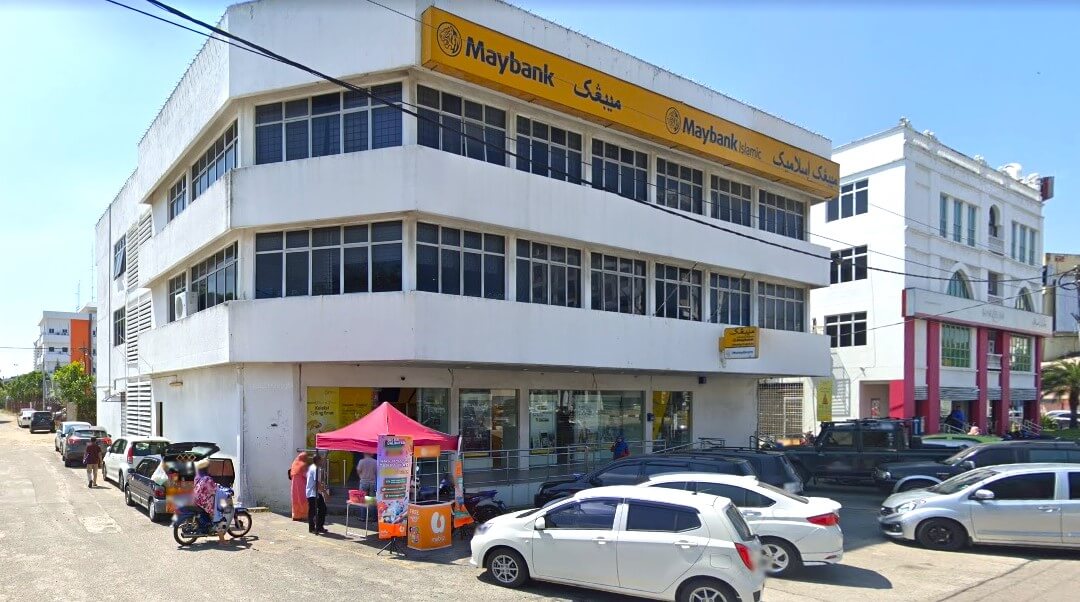 Eksterior Maybank Kota Bharu Main Branch dari hadapan di Jln Mahmood, Bandar Kota Bharu, 15200 Kota Bharu, Kelantan. Pejabat tiga tingkat itu menampilkan cat putih dan papan tanda besar di dinding luar tingkat tiga