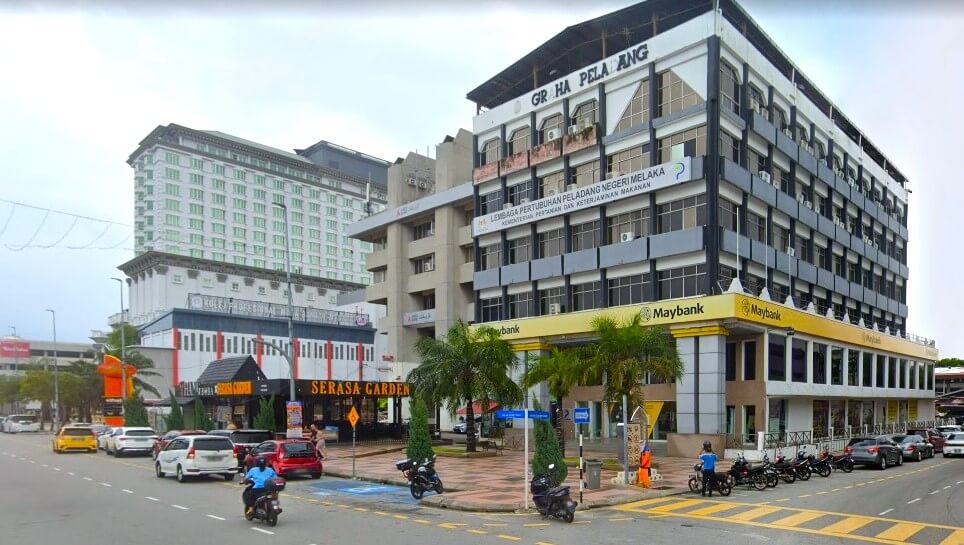 Ekterior Maybank Melaka Main Branch yang terletak di Graha Peladang, Jalan Hang Tuah, 75300 Melaka. Bangunan ini mempunyai gabungan cat kelabu, hitam dan putih. Papan nama dan logo Maybank di dinding tingkat satu mengelilingi bangunan
