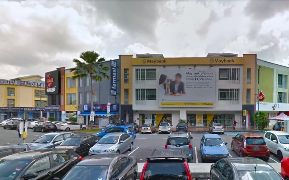 Bangunan utama adalah cawangan Maybank Seremban 2 yang terletak di kawasan komersial kecil. Selain Maybank, ada Farmasi, kedai Multicare. Papan tanda besar di bangunan Maybank menunjukkan dua orang, mungkin pelanggan atau pekerja, dan beberapa maklumat promosi dalam bahasa Melayu, termasuk kadar faedah 3.05%