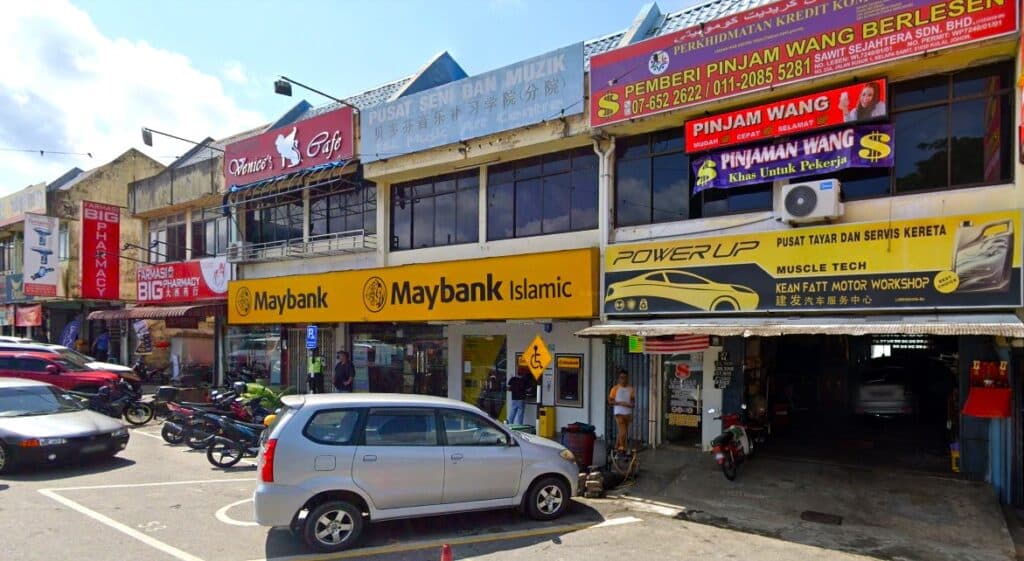 Foto menunjukkan pejabat Maybank Sri Paya - Maybank Kelapa Sawit SC, terletak di kawasan komersial dengan banyak kiosk