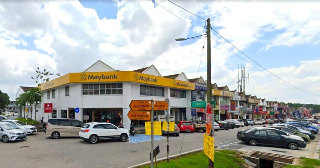 Foto pejabat cawangan Maybank Taman Universiti yang didominasi warna putih kuning mengelilingi deretan kiosk dua tingkat tepat di 1, Jalan Budaya 4, Taman Universiti, 81300 Skudai