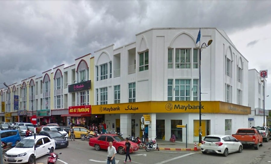 Bahagian luar pejabat Maybank Tanah Merah, dilihat dari bahagian hadapan dan kanan, terletak di Kompleks Perniagaan Humaira, Jalan Humaira 1. Pejabat tiga tingkat itu menampilkan cat putih terang dan papan tanda besar di dinding luar tingkat bawah