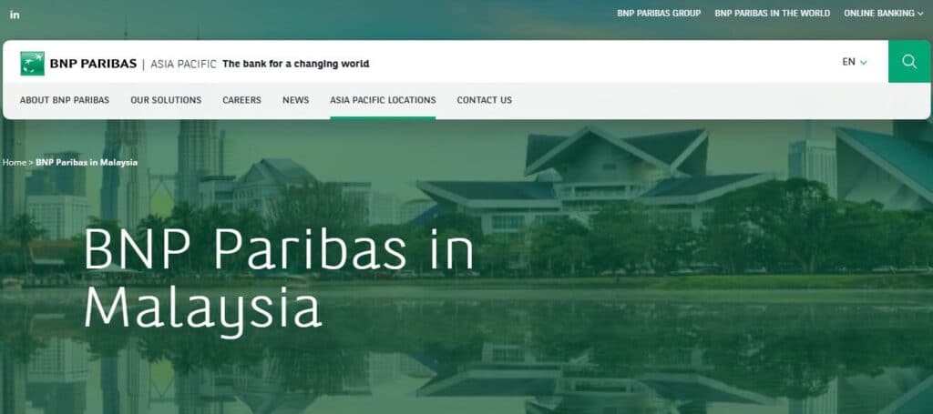 Tangkapan skrin halaman utama laman web BNP Paribas Malaysia, memaparkan tajuk 'BNP Paribas in Malaysia' di atas imej latar langit Kuala Lumpur yang dipantulkan dalam air, dengan bar navigasi utama kelihatan di atasnya