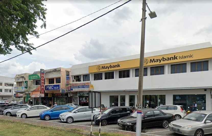 Foto siang hari menunjukkan deretan kedai, dengan latar depan bangunan cawangan Maybank Jelapang berwarna kuning dan putih terang di hadapan. Bangunan ini mempunyai tingkap besar di tingkat bawah dan tingkap yang lebih kecil di tingkat dua. Papan tanda Maybank menggunakan gabungan tulisan Latin dan Arab. Di sebelah kiri, beberapa siri rumah kedai lama yang berwarna-warni mempunyai pelbagai papan tanda perniagaan, termasuk "Honda" dan "PMC."