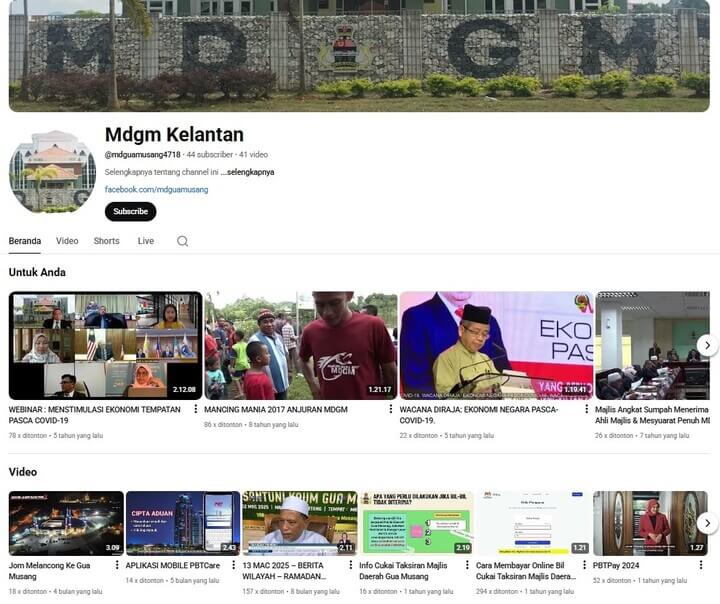 Tangkapan skrin halaman saluran YouTube "Mdgm Kelantan" untuk Majlis Daerah Gua Musang, menunjukkan sepanduk saluran dengan tulisan 'MDGM' dalam batu, bilangan pelanggan dan senarai lakaran kecil video