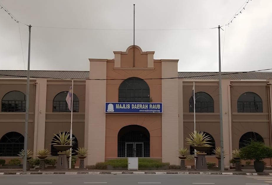 Bahagian luar bangunan pejabat Raub District Council. Bangunan dua tingkat dengan tingkap lebar di setiap bilik. Di atas pintu utama terdapat logo dan tulisan Majlis Daerah Raub