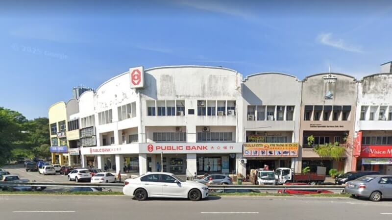 Pandangan hadapan deretan bangunan kedai cawangan Public Bank di Salak South dengan kereta diletakkan di sepanjang jalan.