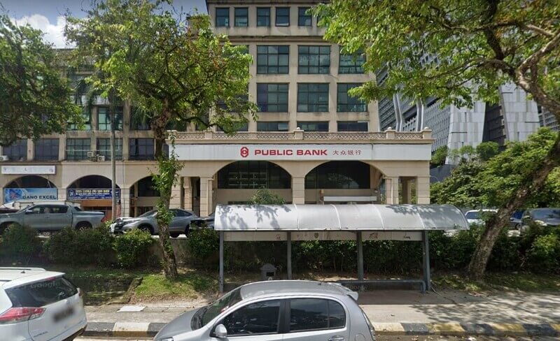 Bangunan Public Bank Sentul dengan papan tanda jenama, perhentian bas di hadapan, serta deretan pokok dan kenderaan di tepi jalan.