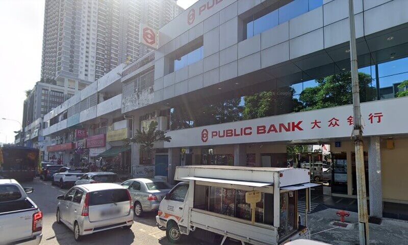 Bangunan cawangan Public Bank Seri Petaling dua tingkat dengan papan tanda merah bertulis "PUBLIC BANK" dan tulisan Cina. Di hadapan bangunan terdapat laluan jalan raya dengan beberapa buah kereta yang diletakkan dan sebuah trak putih kecil.
