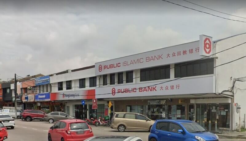 Pandangan luaran deretan rumah kedai yang menempatkan cawangan Public Bank Skudai dan Public Islamic Bank dengan kenderaan diletakkan di bahagian hadapan.