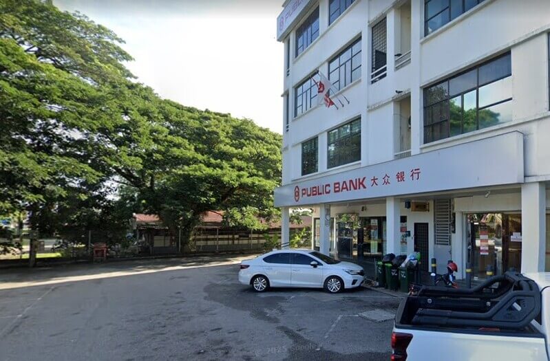 Bangunan cawangan Public Bank Gurun tiga tingkat dengan papan tanda nama bank dalam bahasa Inggeris dan Cina, serta sebuah kereta sedan putih diletakkan di hadapan premis.
