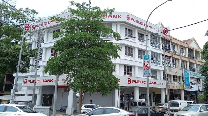 Bangunan cawangan Public Bank di Overseas Union Garden pada waktu siang dilihat dari seberang jalan yang terdapat pokok dan kereta meletak kenderaan