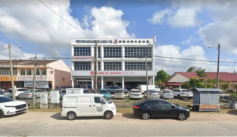 Pandangan hadapan bangunan tiga tingkat Public Bank Bukit Pasir dengan deretan kenderaan di kawasan tempat letak kereta di hadapannya.