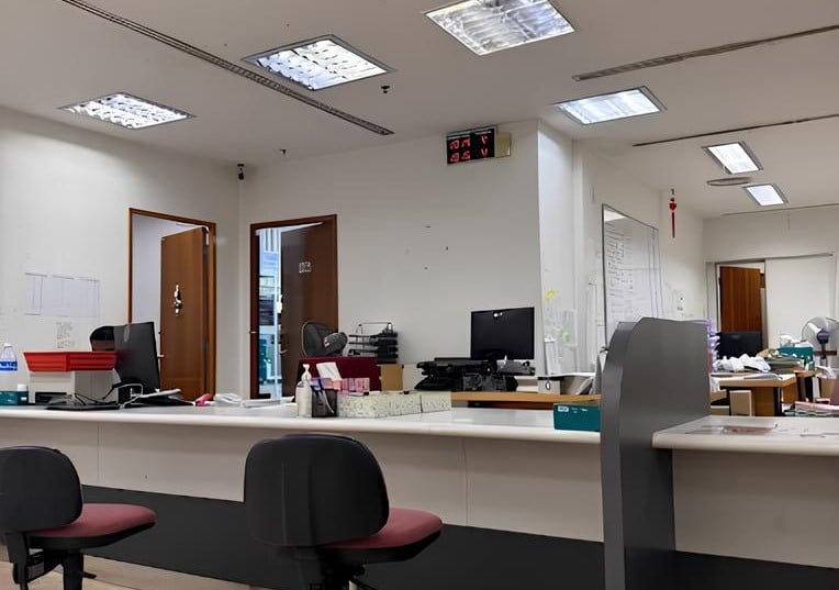 Bahagian dalam cawangan Public Bank di Jalan Sultan Sulaiman. Di latar depan terdapat kaunter perkhidmatan dengan dua kerusi pejabat kosong gelap ditarik ke sisi pelanggan