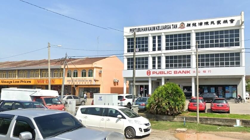 Foto bangunan Public Bank di Bukit Pasir, Malaysia. Bangunan ini berwarna putih dengan logo Public Bank dan bertulisan merah di tingkat satu. Di atas logo, nama bangunan ditulis dalam bahasa Inggeris, "PERTUBOHAN KAUM KELUARGA TAN," dan dalam bahasa Mandarin