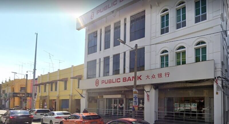 Bangunan cawangan Public Bank Jalan Abdullah tiga tingkat berwarna putih dengan papan tanda cawangan dan deretan kereta di hadapannya.
