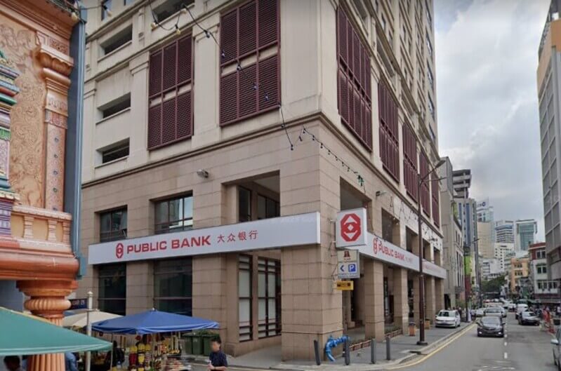 Pemandangan sudut bangunan cawangan Public Bank di Jalan Tun H.S. Lee dengan papan tanda bertulis "PUBLIC BANK" dalam bahasa Inggeris dan Cina.