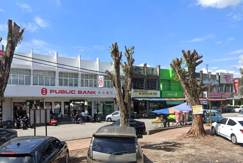 ahagian luar cawangan Public Bank Kuala Ketil yang terletak di kawasan komersial yang sibuk. Nama bank itu jelas kelihatan dalam huruf merah pada fasad putih, bersama-sama dengan nama Cinanya