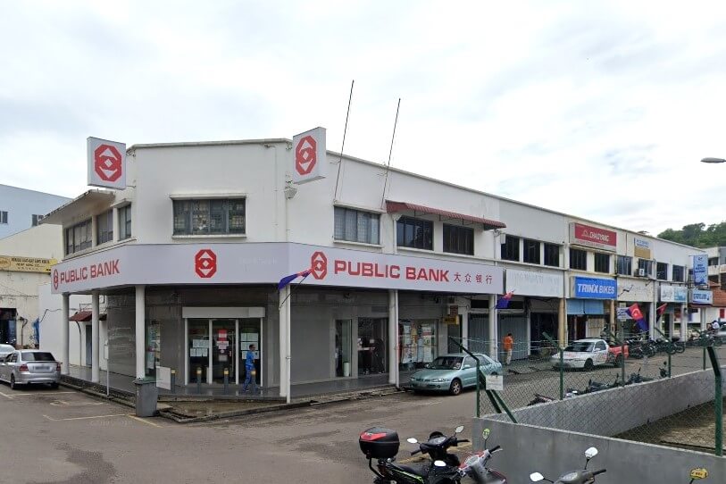 Gambar luaran bangunan Public Bank Mersing di Mersing, Malaysia, dari aras jalan. Bangunan itu adalah struktur putih dua tingkat dengan aksen merah dan logo bank. Terdapat beberapa kedai di sebelah kanan bank, termasuk kedai Trinx Bikes