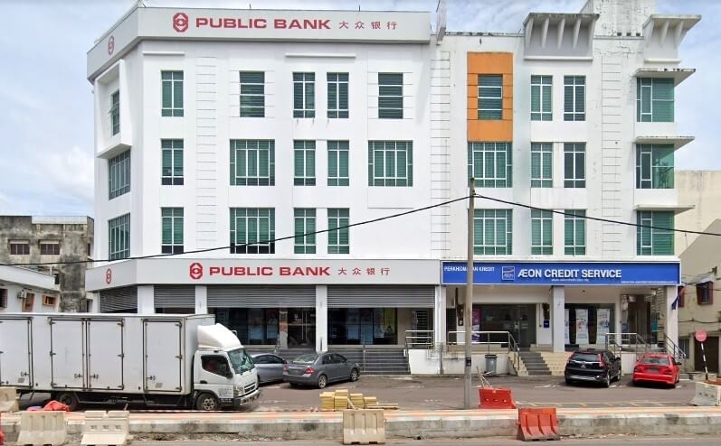 Foto Public Bank Segamat dua tingkat di Segamat, Malaysia. Bangunan itu berwarna putih dengan papan nama Public Bank merah dan kelabu di tingkat atas dan papan tanda yang lebih kecil di tingkat bawah