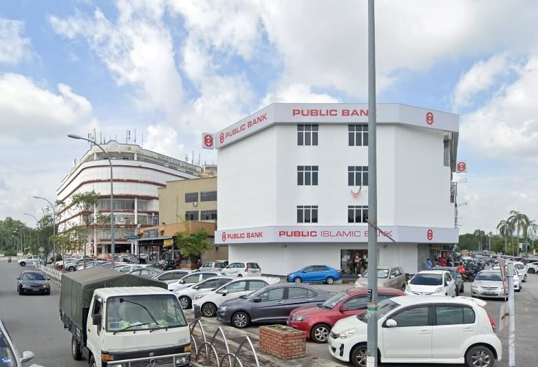 Foto bangunan Public Bank di Sungai Petani, Malaysia, ialah sebuah bangunan bertingkat berwarna putih dengan trim dan huruf merah. Di hadapannya adalah kawasan parkir asfalt yang sibuk dipenuhi dengan banyak kereta dan sebuah lori putih