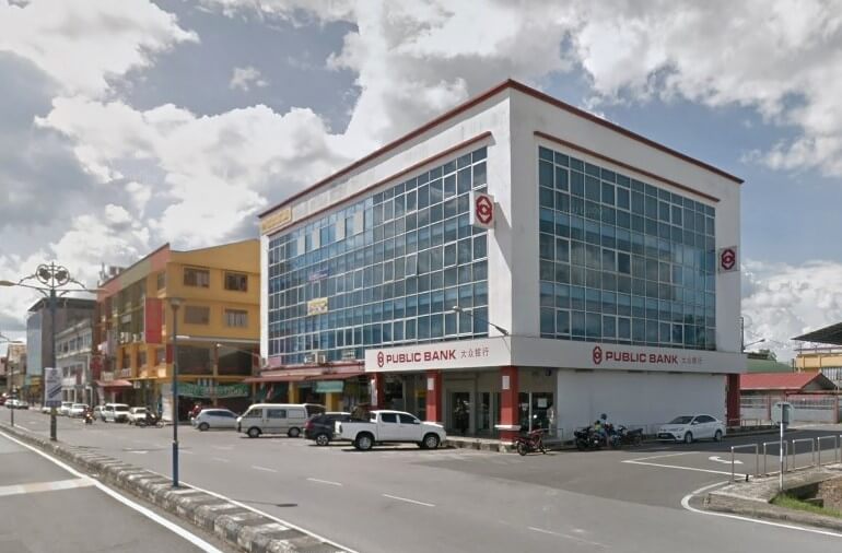 Gambar luaran cawangan Public Bank di Bintangor dari aras jalan. Bangunan moden empat tingkat putih dengan trim merah dan tingkap biru ini menghadap ke jalan di mana beberapa kereta dan motosikal diletakkan. Logo dan nama bank boleh dilihat di tingkat bawah
