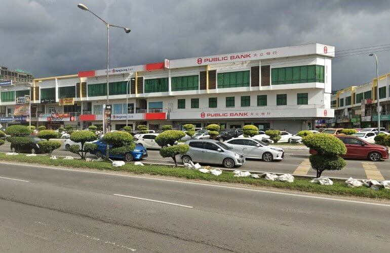 Kompleks bangunan tiga tingkat yang menempatkan Public Bank Inanam, Malaysia. Bangunan ini mempunyai fasad moden dengan dinding putih, hiasan merah, dan tingkap hijau segi empat tepat. Nama bank itu jelas dipaparkan dalam warna merah di tingkat atas, dalam kedua-dua aksara Inggeris dan Mandarin