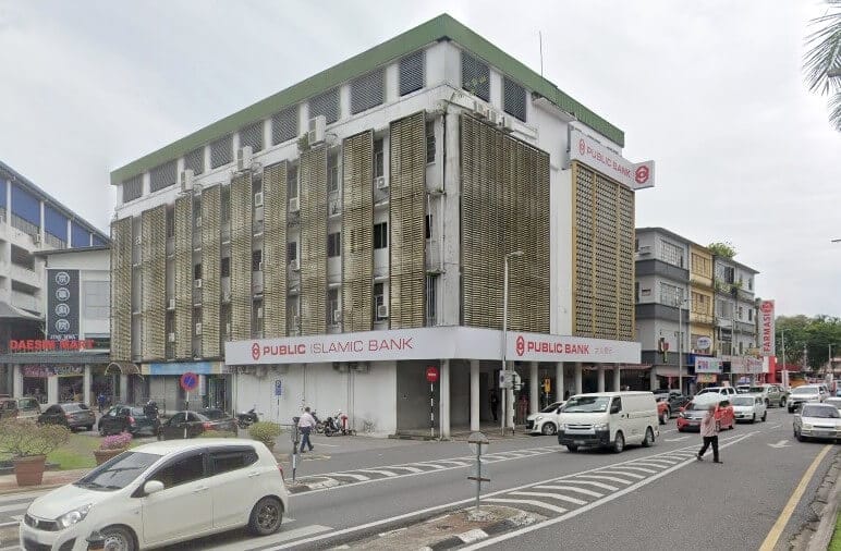 Pemandangan luar bangunan Public Bank & Public Islamic Bank di sudut jalan bandar dengan lalu lintas dan pejalan kaki