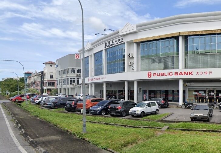 Pandangan luar bangunan cawangan Public Bank Jalan Tun Zaidi dari aras jalan, dengan deretan kereta yang diletakkan di latar depan dan jalan ke paling kiri. Bangunan itu adalah blok komersial tiga tingkat dengan fasad putih dan logo Public Bank berwarna merah