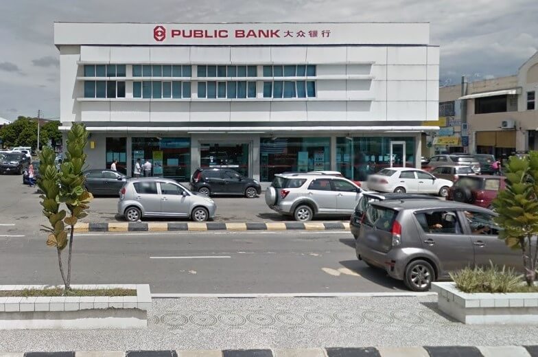 Pandangan luar cawangan Public Bank (大众银行) dua tingkat di Papar, dengan jalan raya dan beberapa kereta di latar depan