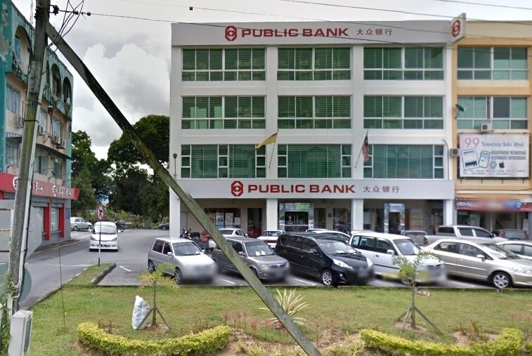 Bangunan Public Bank Sarikei bertingkat dengan logo dan nama Cina (大众银行) boleh dilihat dengan jelas pada hari yang cerah. Terdapat kereta yang diletakkan di hadapan bank, dan jalan yang sibuk kelihatan di sebelah kiri