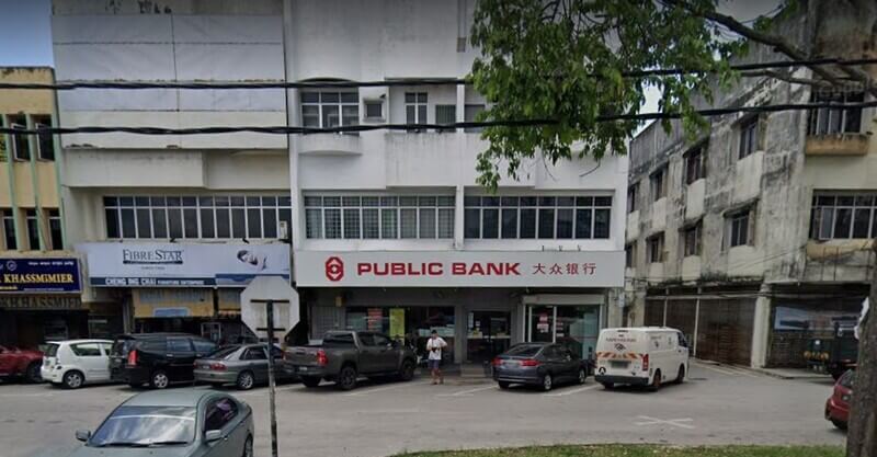 Pemandangan hadapan cawangan Public Bank Ayer Tawar di kawasan kedai dua hingga tiga tingkat, lengkap dengan papan tanda merah dan cina "PUBLIC BANK 大众银行". Beberapa kenderaan diletakkan di hadapan bangunan dan di sepanjang jalan raya