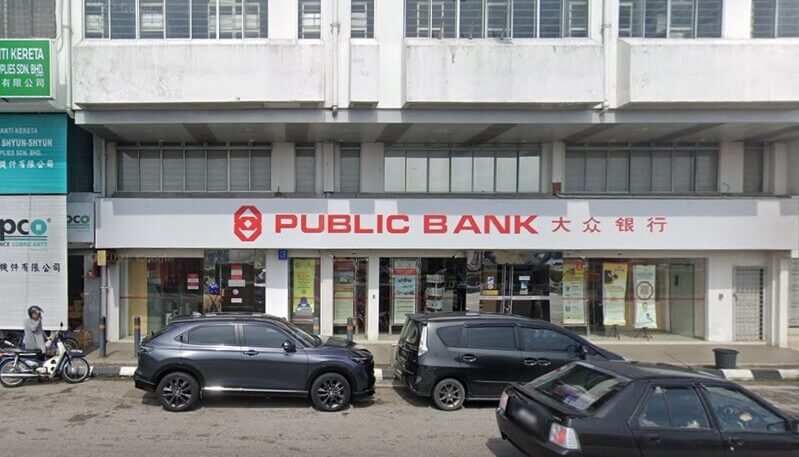 Pandangan hadapan cawangan Public Bank Bagan Serai di bagan kedai dengan papan tanda logo Public Bank dan beberapa buah kereta diletakkan di bahagian hadapan.