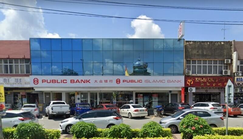 Pemandangan hadapan bangunan cawangan Public Bank Bahau dan Public Islamic Bank dengan cermin biru serta beberapa buah kereta diletakkan di hadapannya.