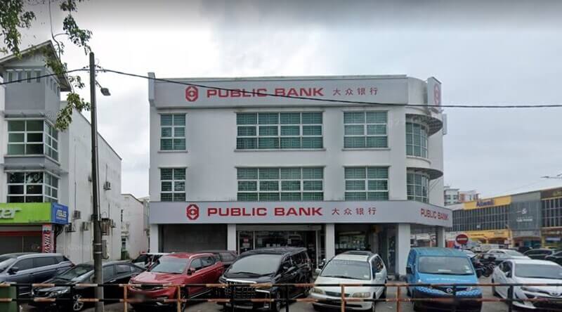 Bangunan cawangan Public Bank Batu Berendam tiga tingkat dengan deretan kereta diletakkan di bahagian hadapan.
