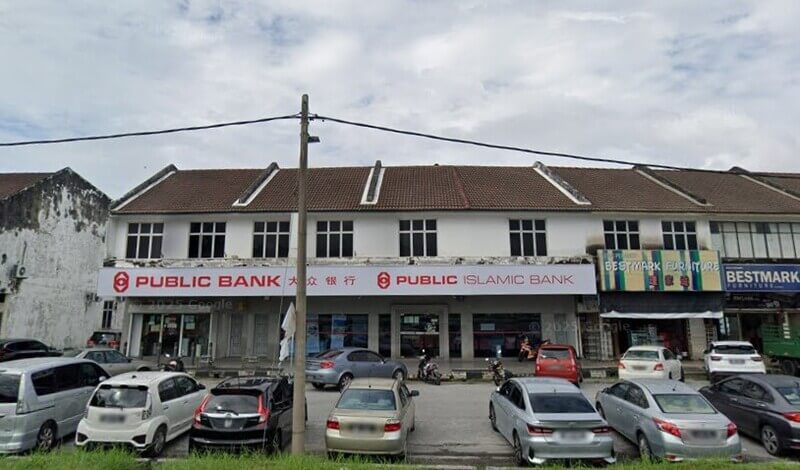Pemandangan hadapan cawangan Public Bank Chemor dan Public Islamic Bank di dalam barisan kedai dua tingkat, dengan beberapa kenderaan diletakkan di tempat letak kereta di hadapannya.