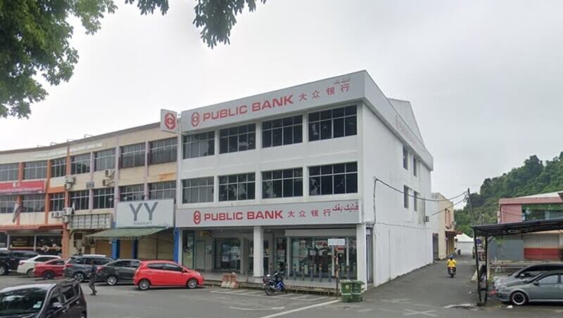 Bangunan kedai tiga tingkat cawangan Public Bank Jerantut berwarna putih dengan papan tanda merah di Jerantut.