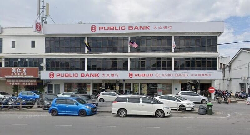 Bangunan Public Bank Kangar tiga tingkat dengan papan tanda Public Bank dan Public Islamic Bank, serta deretan kereta dan motosikal di tempat letak kereta hadapan.