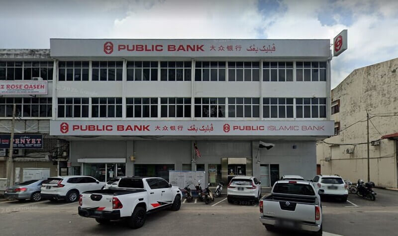 Pandangan hadapan bangunan cawangan Public Bank Kuantan dan Public Islamic Bank tiga tingkat dengan papan tanda dalam tulisan Rumi, Cina, dan Jawi, serta beberapa buah kereta diletakkan di ruang parkir hadapan.