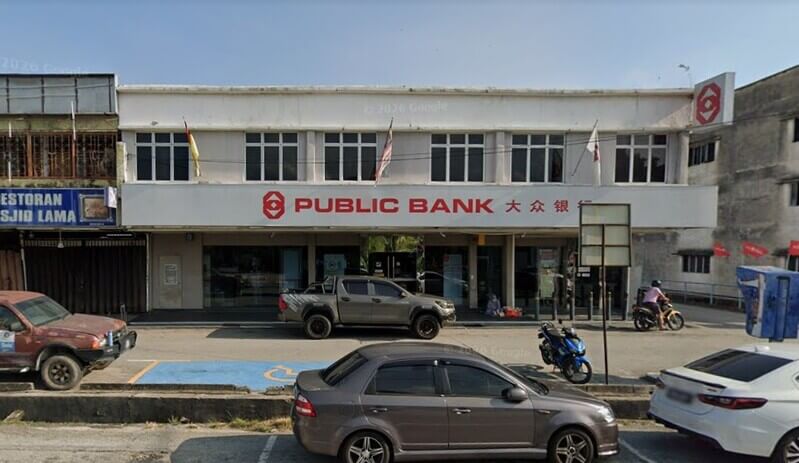 Pandangan hadapan cawangan Public Bank Nilai dua tingkat dengan beberapa buah kenderaan diletakkan di tempat letak kereta.