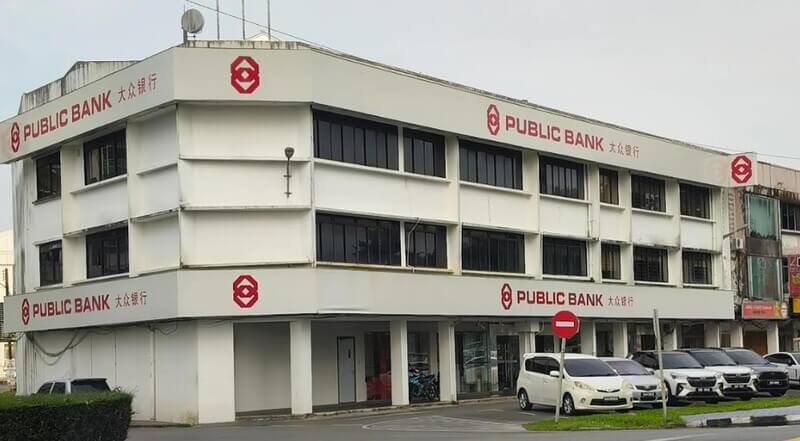 Bangunan cawangan Public Bank Padungan tiga tingkat berwarna putih dengan beberapa buah kereta diletakkan di hadapannya.