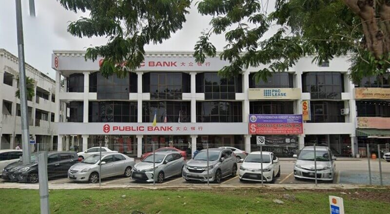 Bangunan cawangan Public Bank Prai tiga tingkat dengan deretan kereta yang diletakkan di tempat letak kereta di bahagian hadapan.